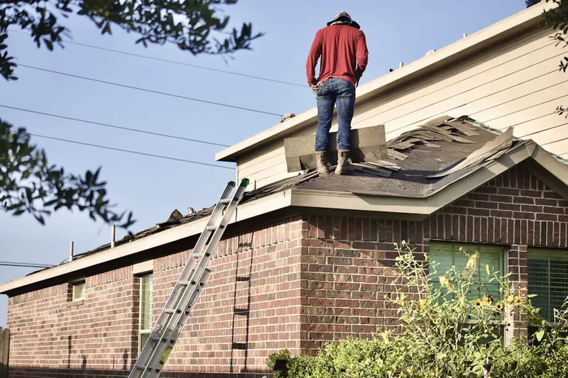Professional roofer working on a residential roof in New Boston